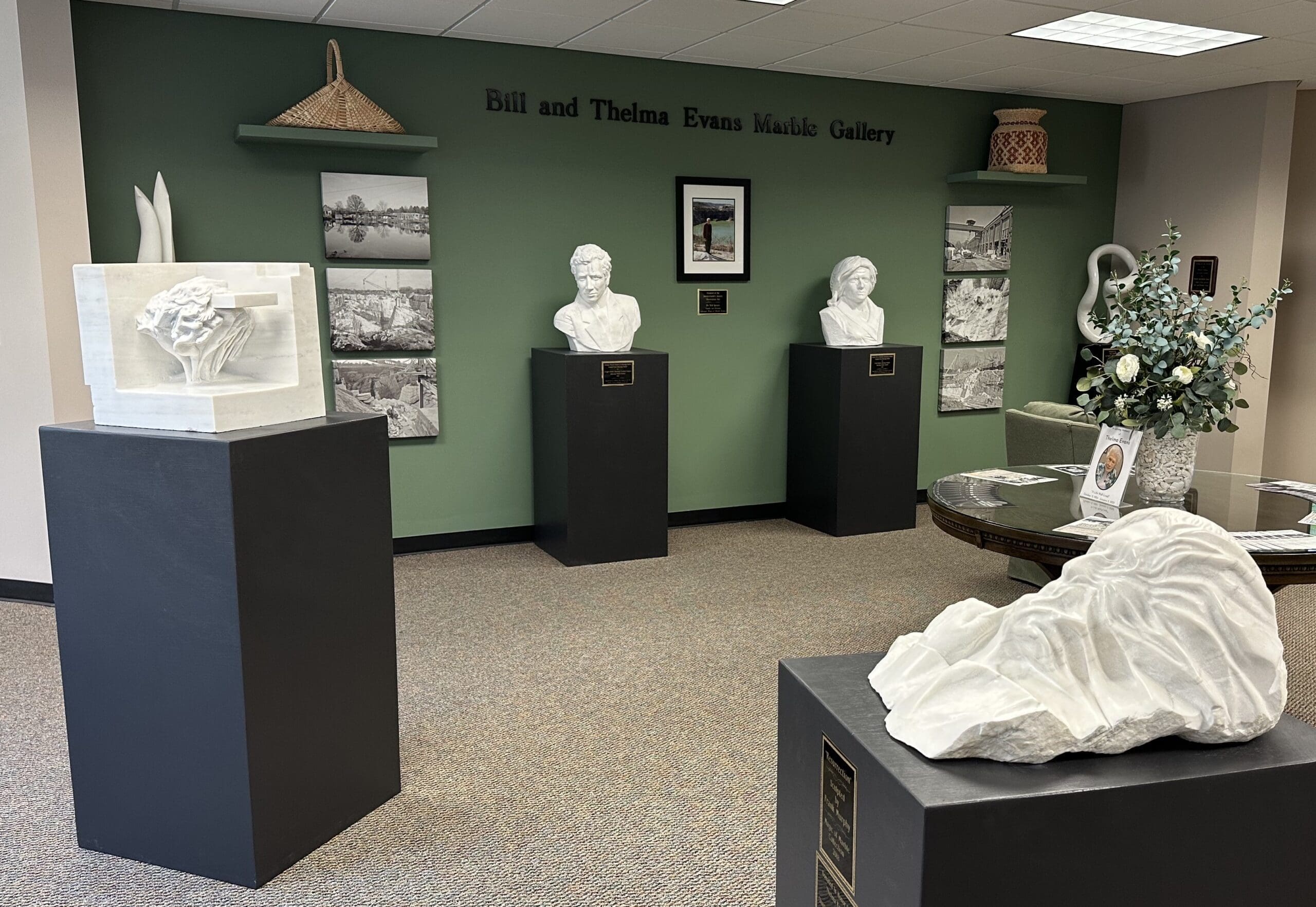 Gallery with various marble sculptures featured on pedestals, located at the Comer Library in Sylacauga, AL.