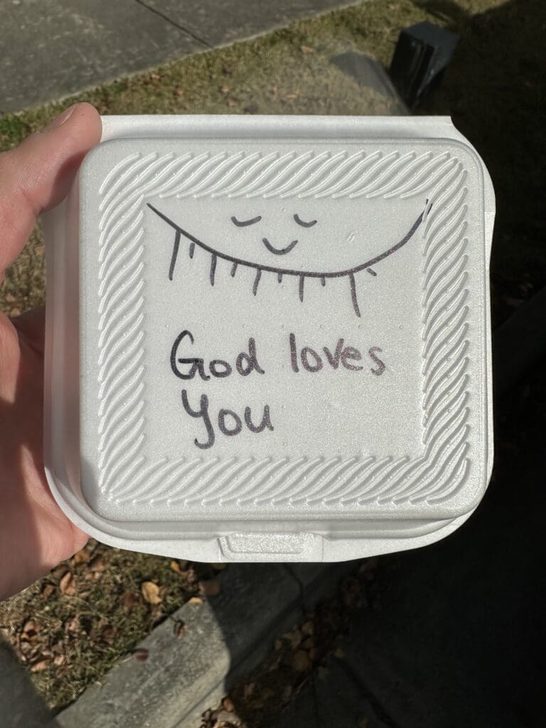 Note reading "God loves you", handwritten on a to-go container.