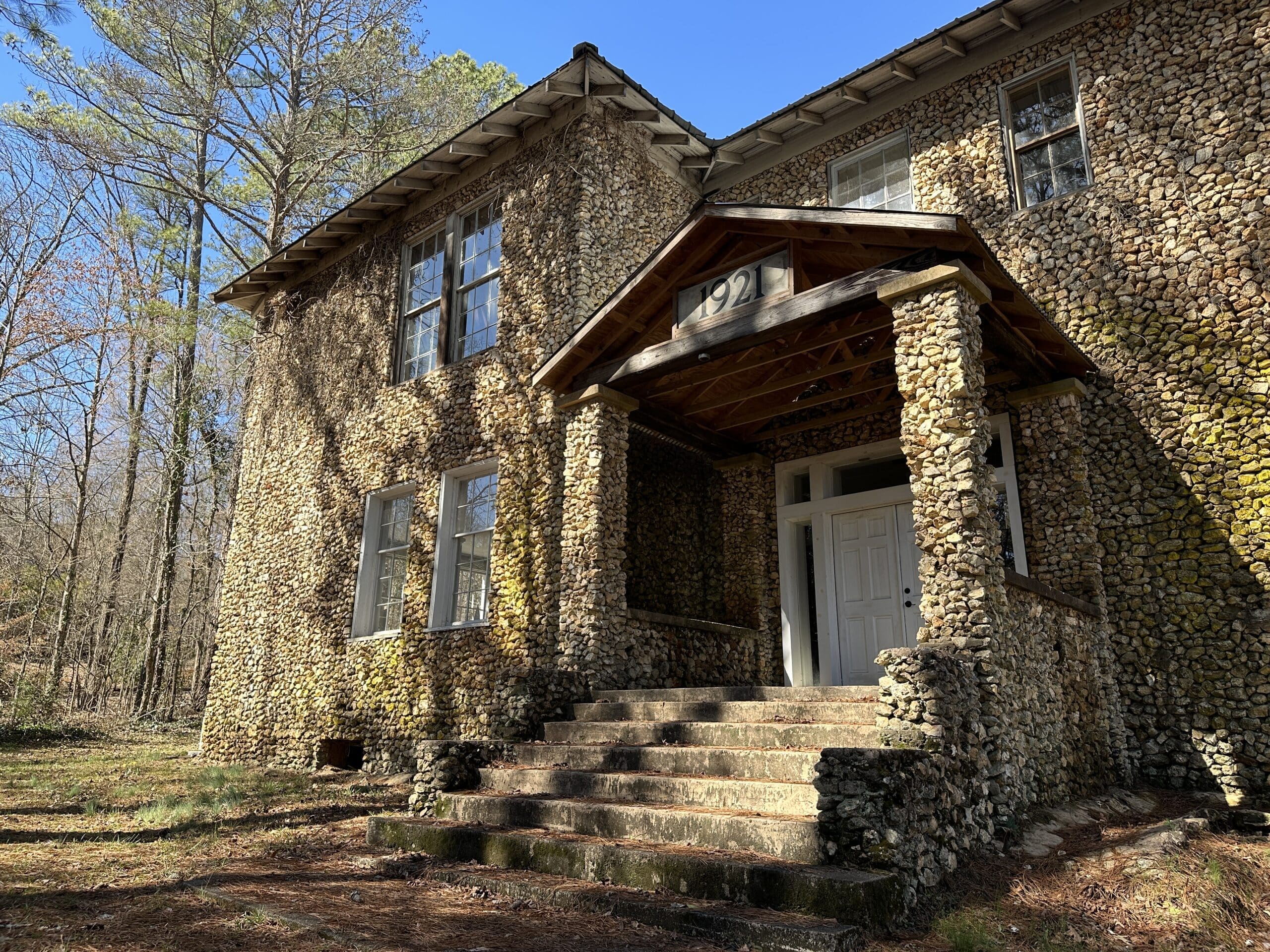 Old school building in Springville, AL with rock wall exterior.