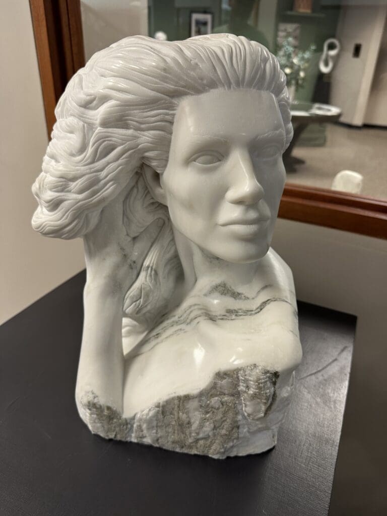 Marble sculpture in Sylacauga's Comer Library of Rapunzel with her hand in her hair. Artist: Frank Murphy.