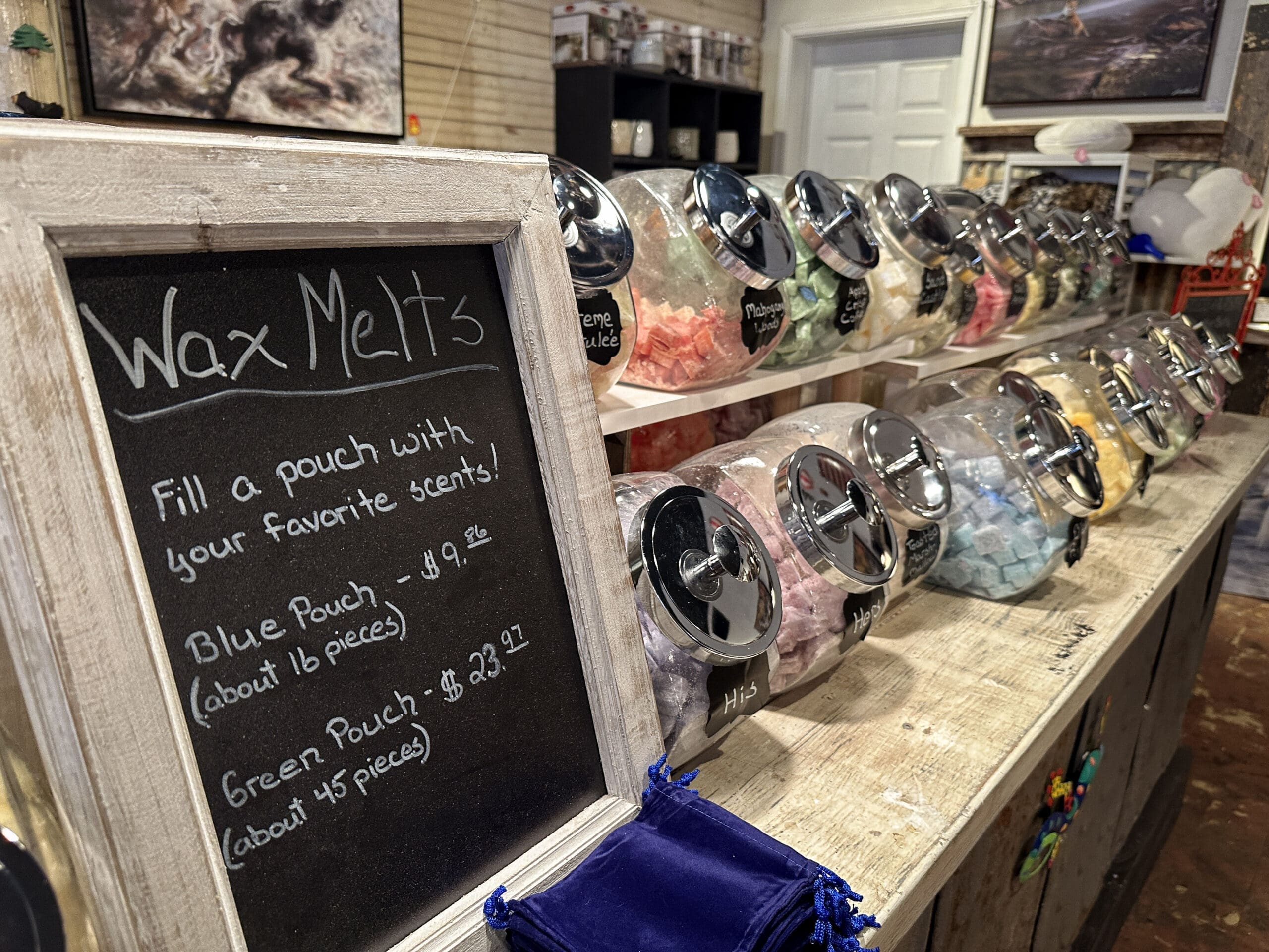A wax melt bar with a sign reading "Fill a pouch with your favorite scents!"