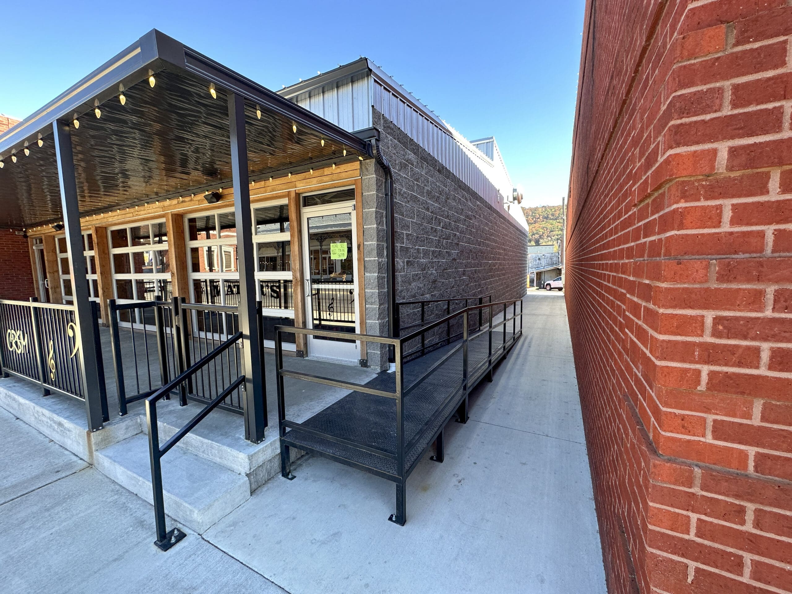 Looking down an alley way with a pizza restaurant on the left and a brick building on the right.