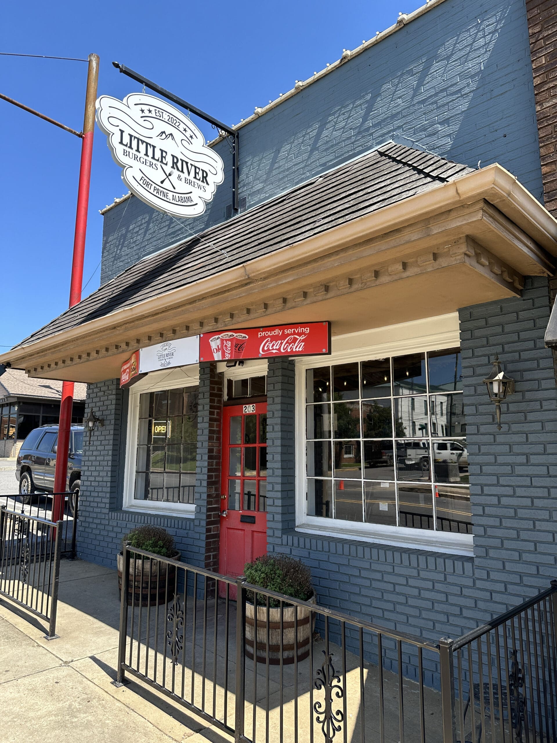 Front of a small restaurant with a sign reading "Little River Brugers & Brews".