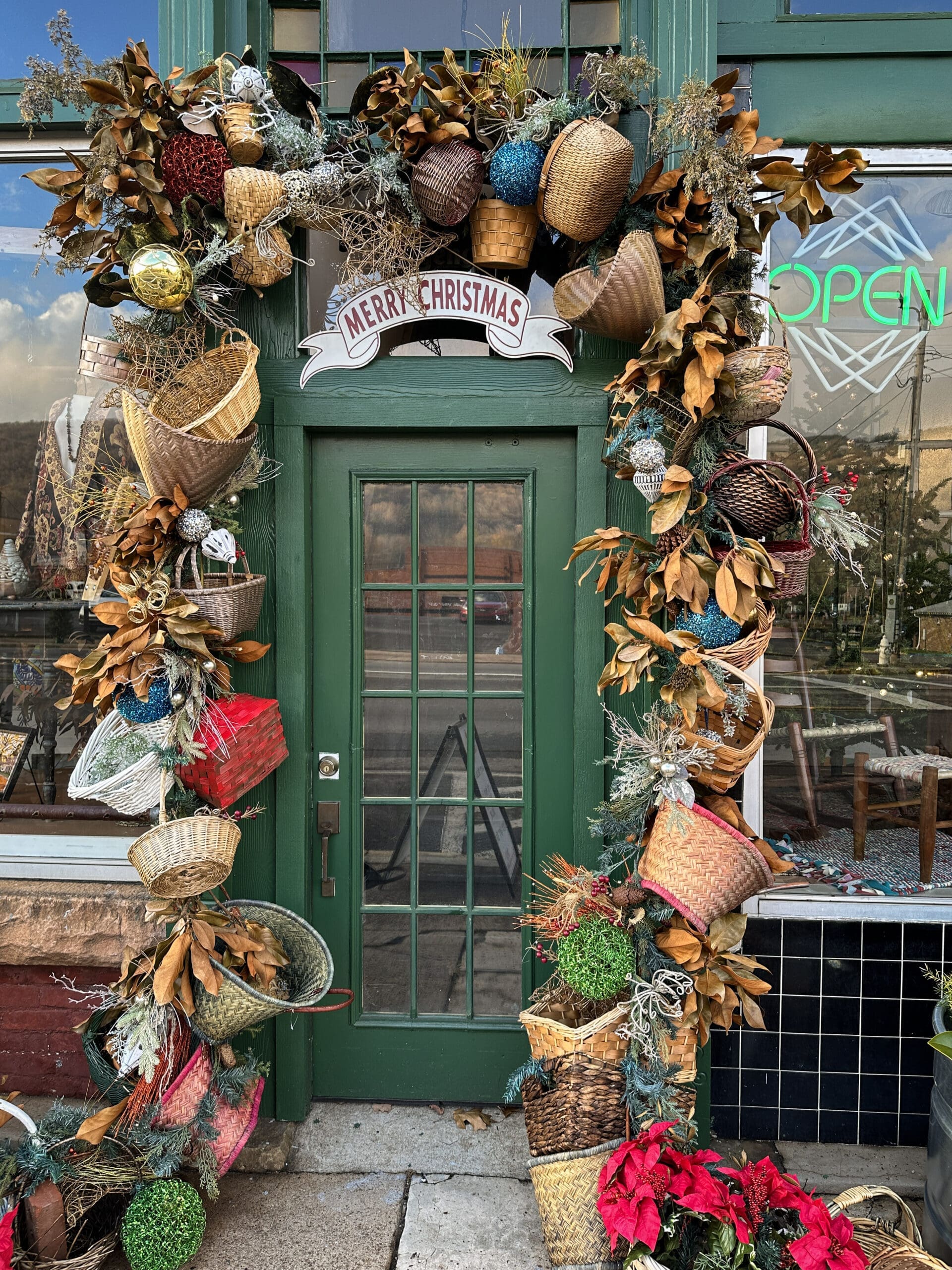 Store front decorated with numerous baskets. Sign above the door reads "Merry Christmas".