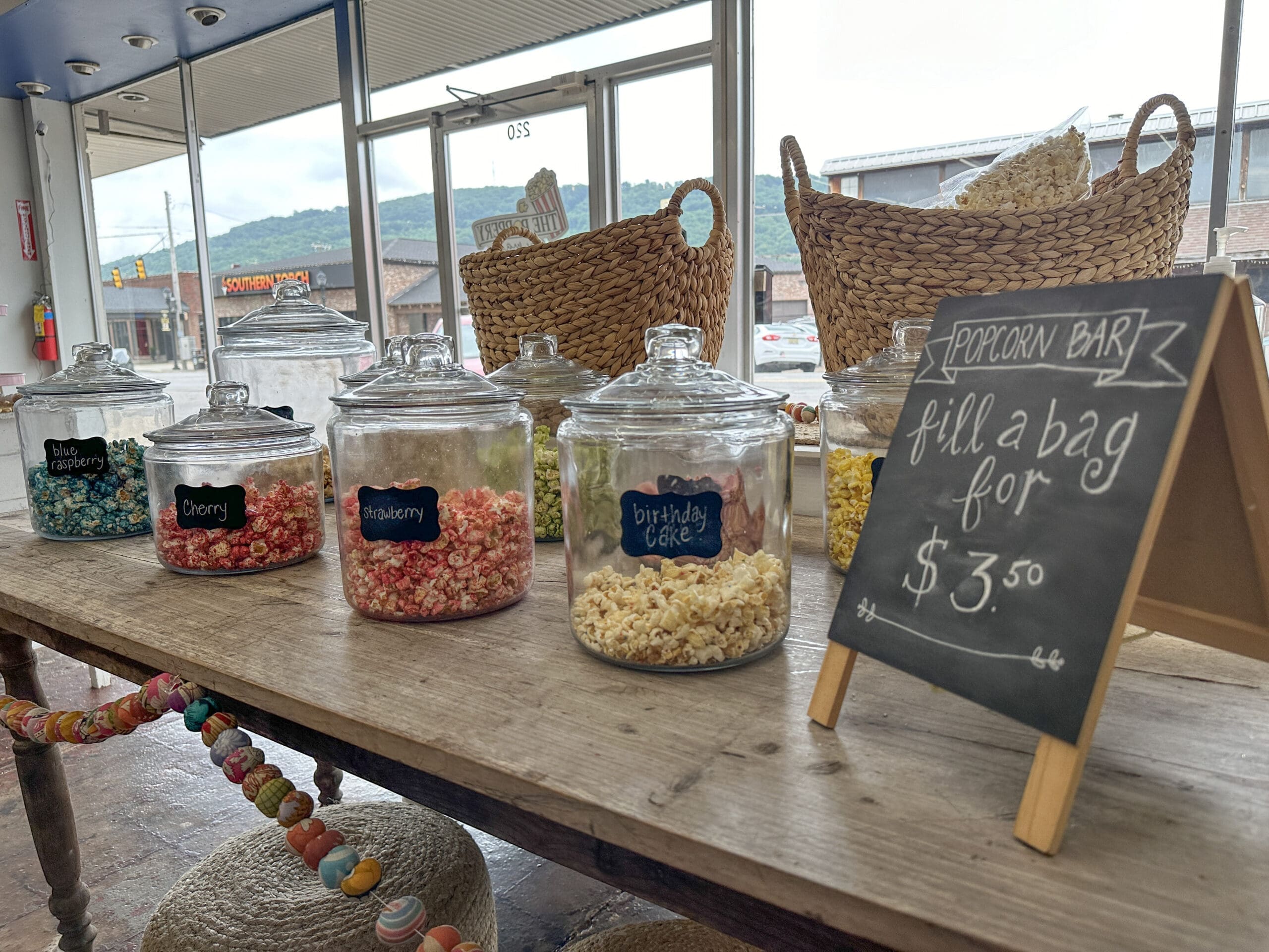 Close-up of a popcorn bar featuring various flavors including birthday cake, strawberry, cherry and blue raspberry.