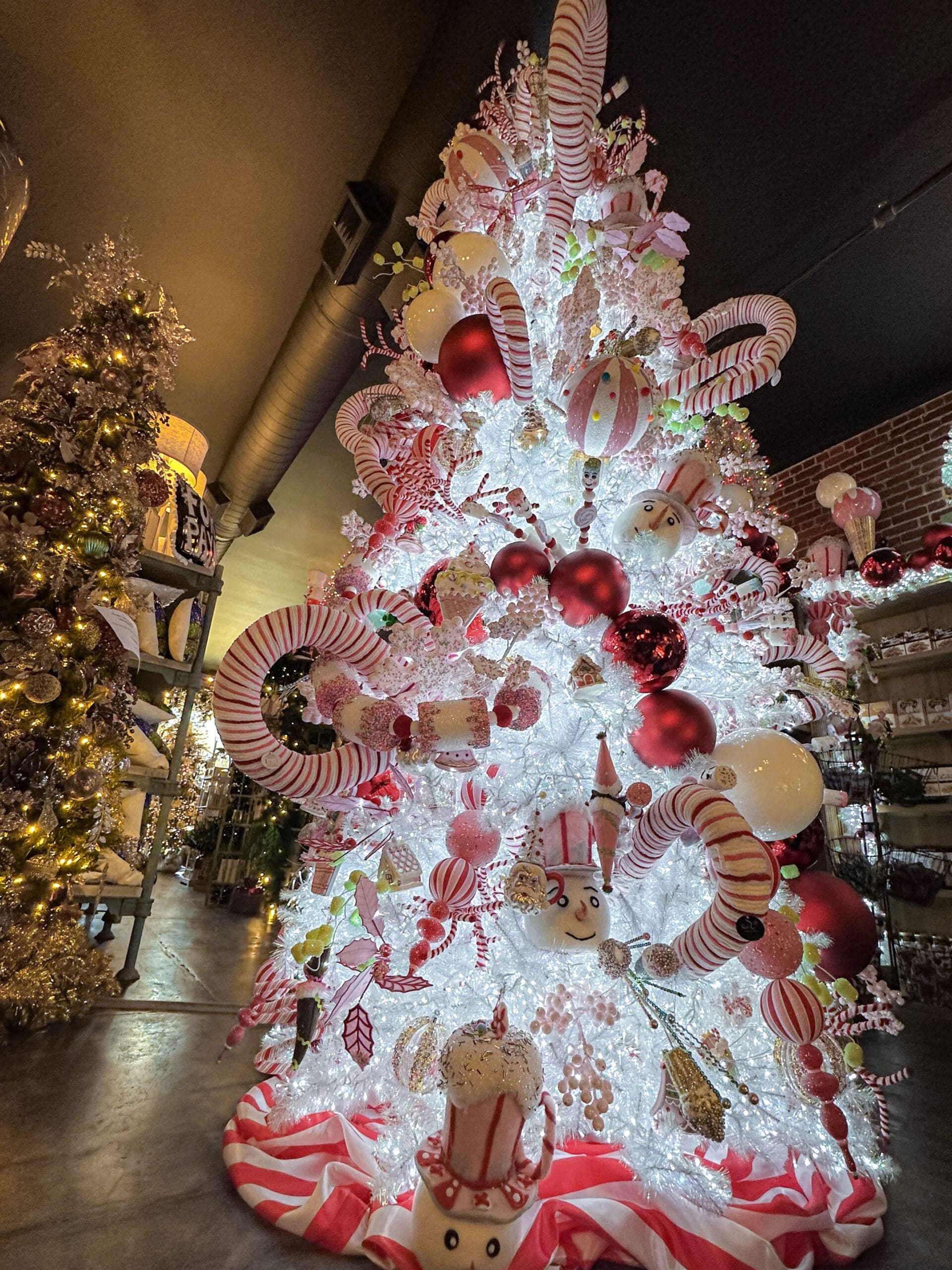 An enormous Christmas tree inside a story. The tree is decorated with enormous fake candy canes.