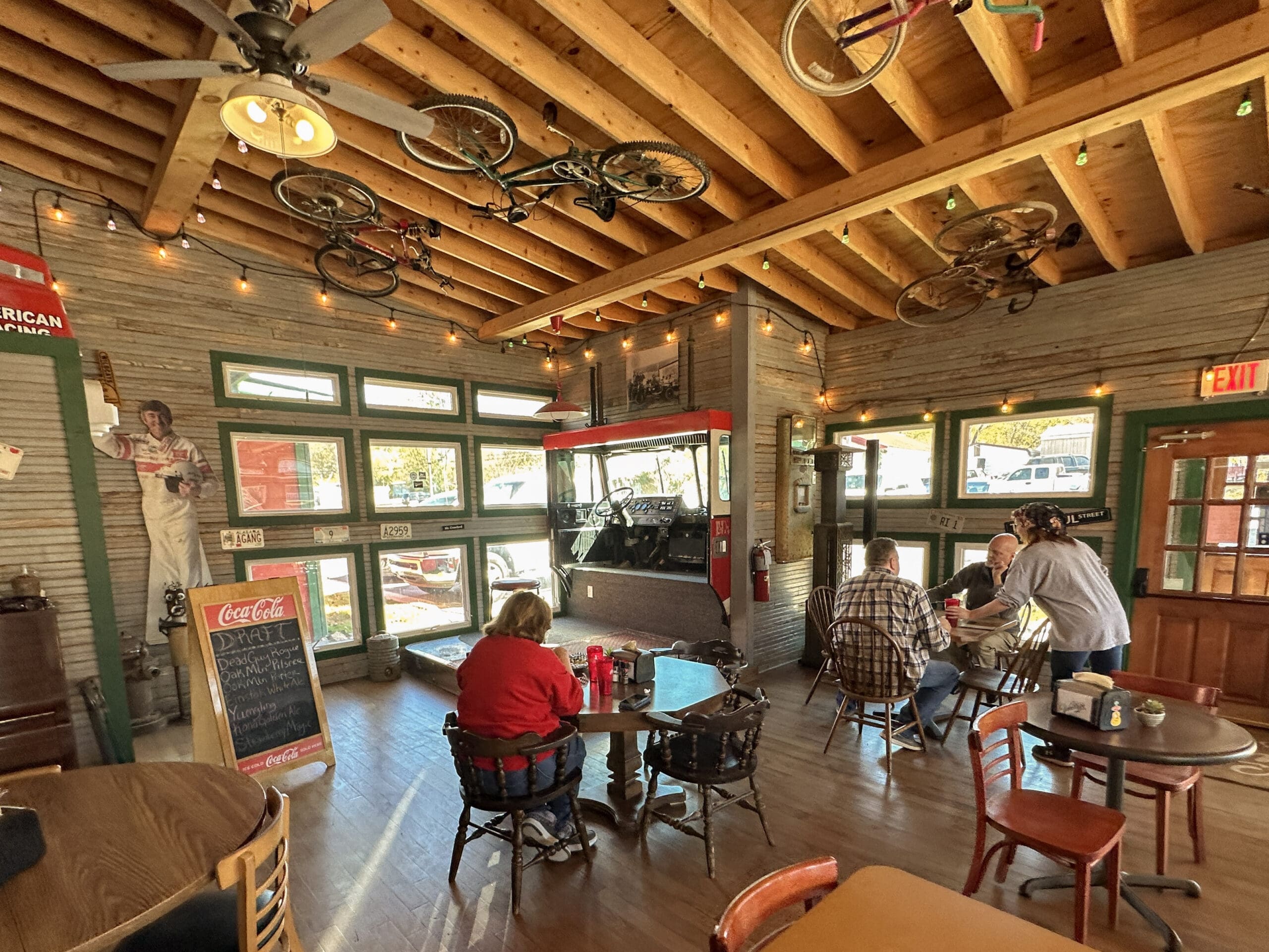 Interior photo of restaurant with the sawed off front of a fire truck in the corner converted into a stage.