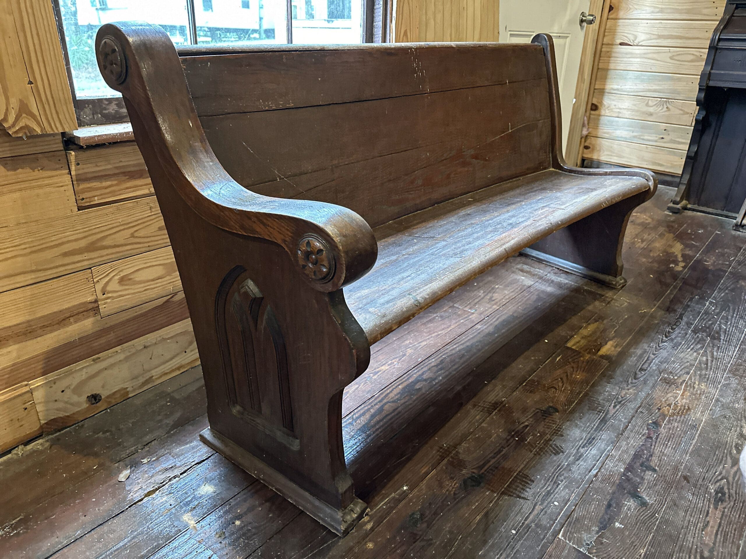 A close-up photo of a wooden pew built in the 1860s.