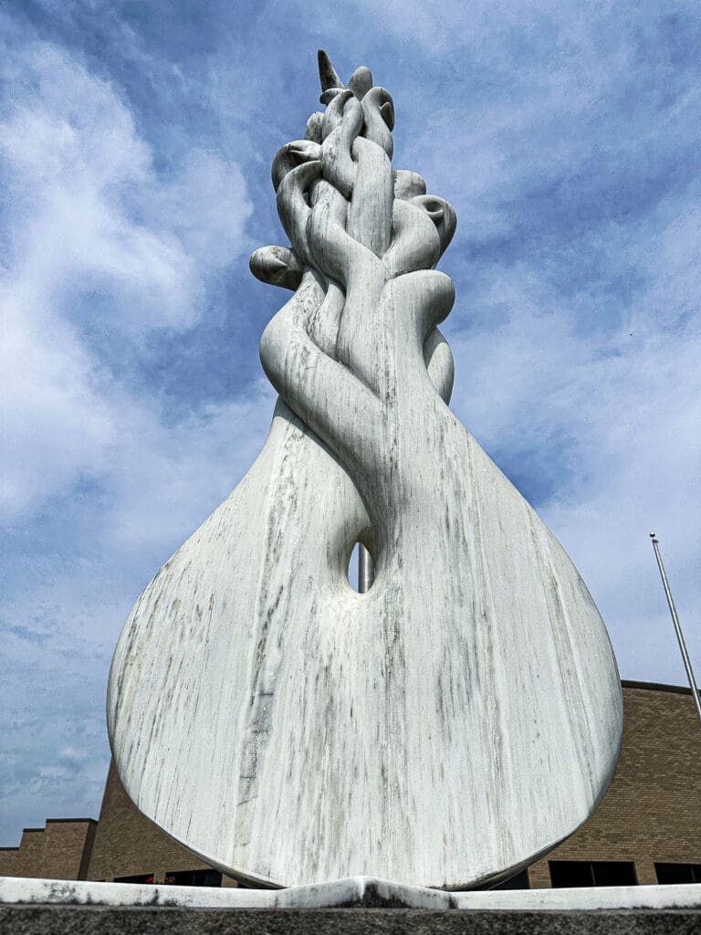 Upward view of a large marble sculpture depicting a meteor at the bottom with a fiery trail. The sculpture is intended as a tribute to the meteorite that struck local woman Ann Hodges.