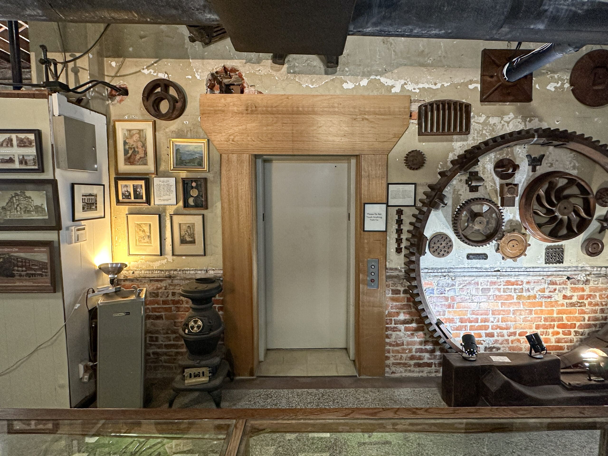 A wood-framed elevator door in a history museum.