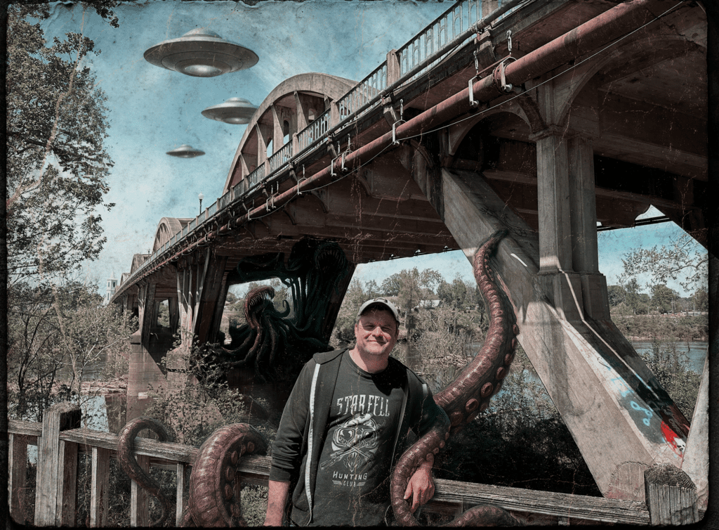 A man with a "StarFell" shirt on standing in front of a bridge. Numerous monsters and UFOs have been edited into the image.